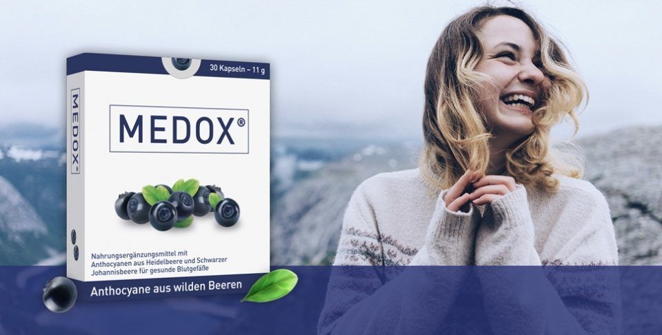 Packung „MEDOX“ Nahrungsergänzungsmittel mit Heidelbeeren und schwarzen Johannisbeeren, beworben für gesunde Blutgefäße. Im Hintergrund Berglandschaft, unten Text „Anthocyane aus wilden Beeren“.