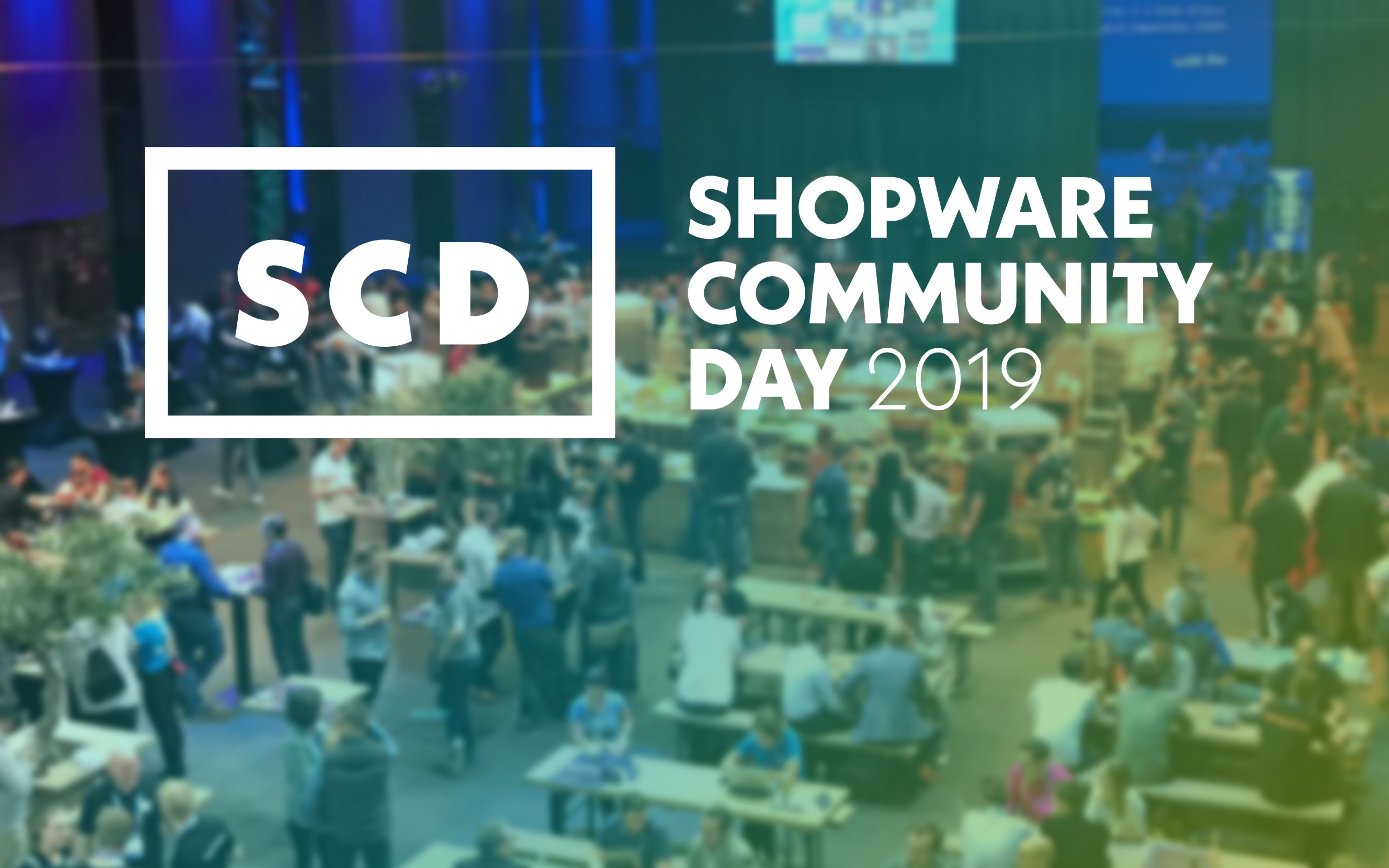 Shopware Community Day Logo mit einem Bild des letzten SCD im Hintergrund.