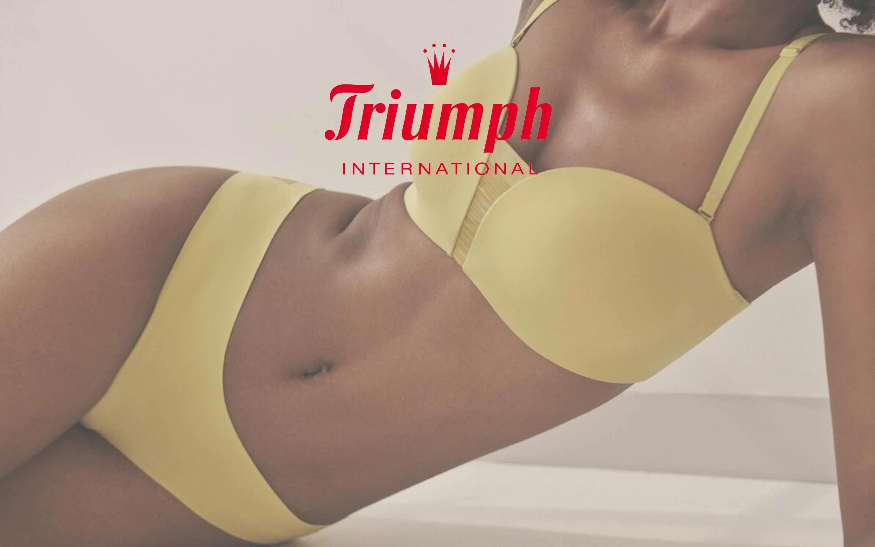 Woman lying on her side, propped up on one elbow, wearing a yellow underwear set consisting of a bra and panties, smooth and without texture. At the top of the image is the logo of the brand ‘Triumph International’.