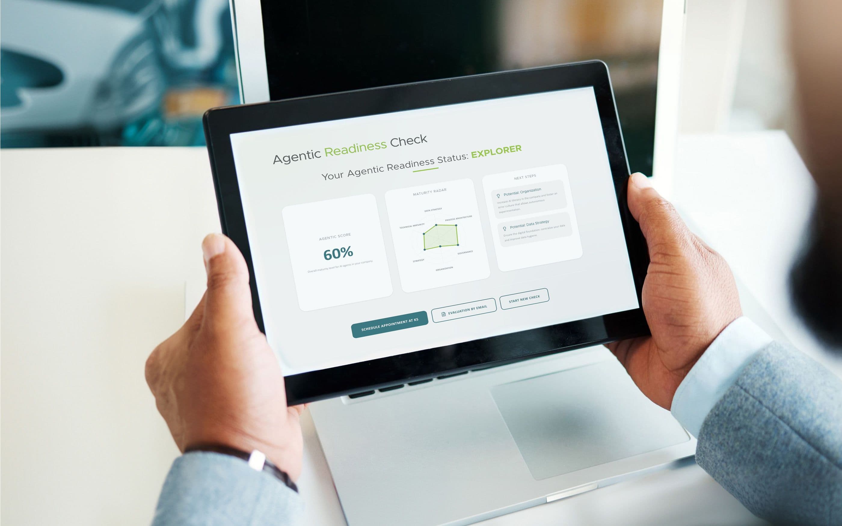 A person is holding a tablet displaying the “Agentic Readiness Status: Explorer” dashboard. The screen shows a score of 60%, a radar chart covering strategy, governance, and organization, as well as recommended next steps and action buttons at the bottom.