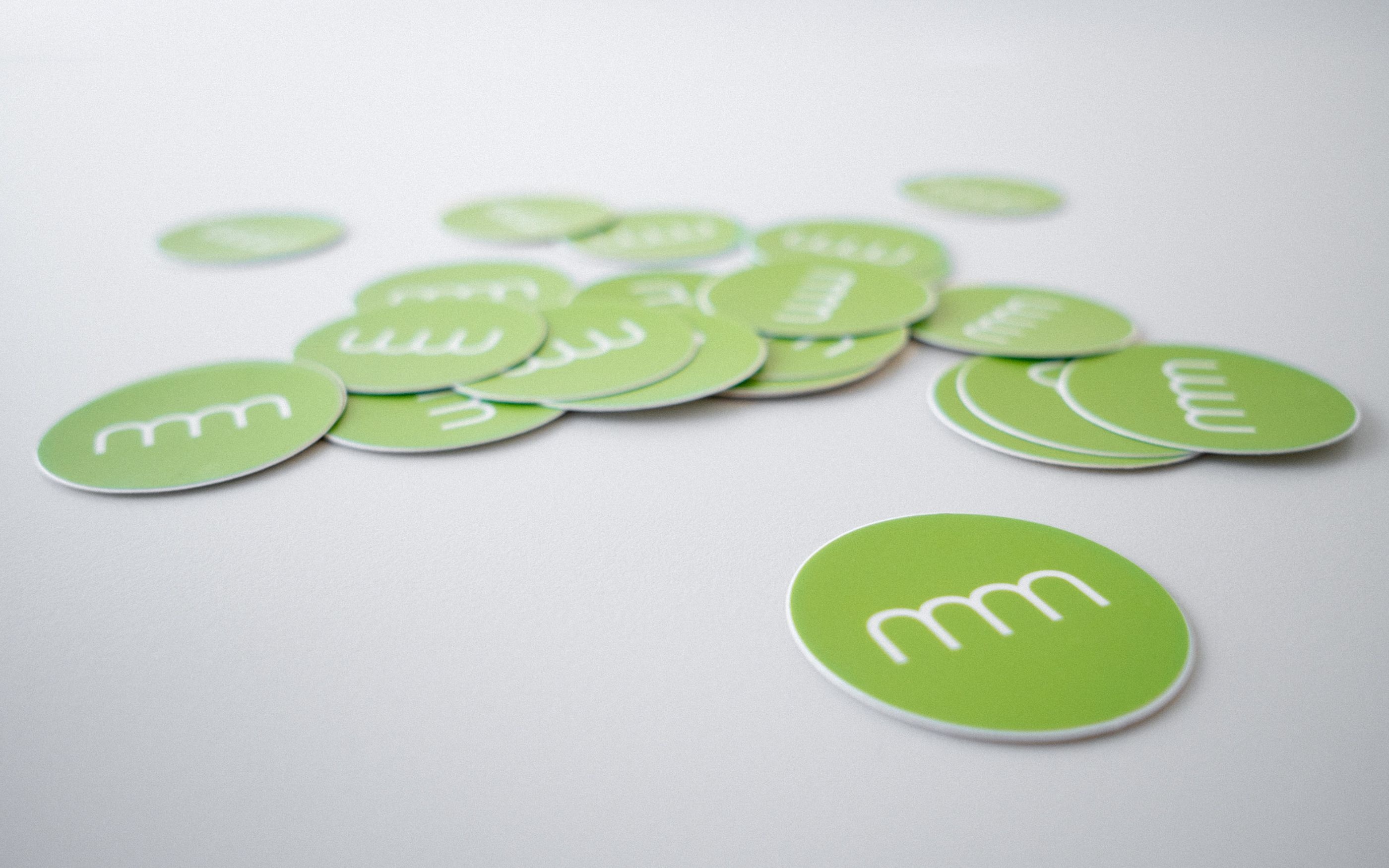 Foto von einigen Sticker-Aufklebern mit communicode Signet auf weißem Tisch