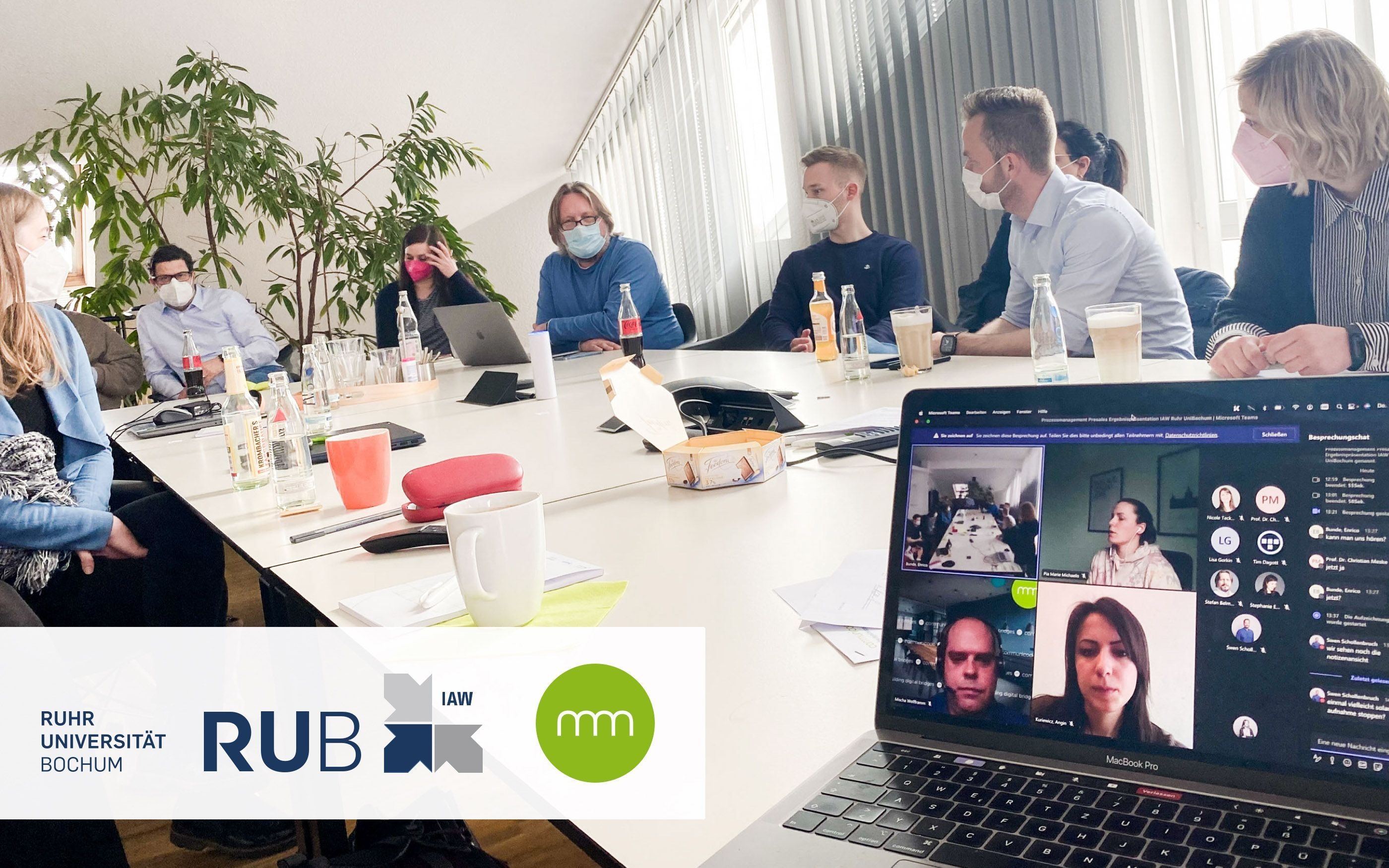Besprechungsraum mit communicode Mitarbeitern und Logo der Ruhruniversität Bochum